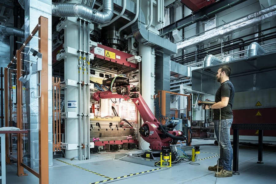 Im Infrarotofen oder Umluftofen vorgeheizte Halbzeuge können mit einem Sieben-Achs-Roboter aus dem Ofen entnommen und in das Werkzeug zur Weiterverarbeitung eingelegt werden.